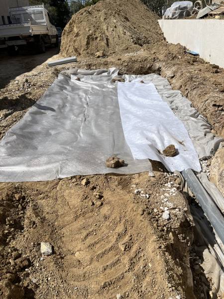 Préparation d’un drain périphérique avec géotextile déployé sur l’ensemble de la zone.